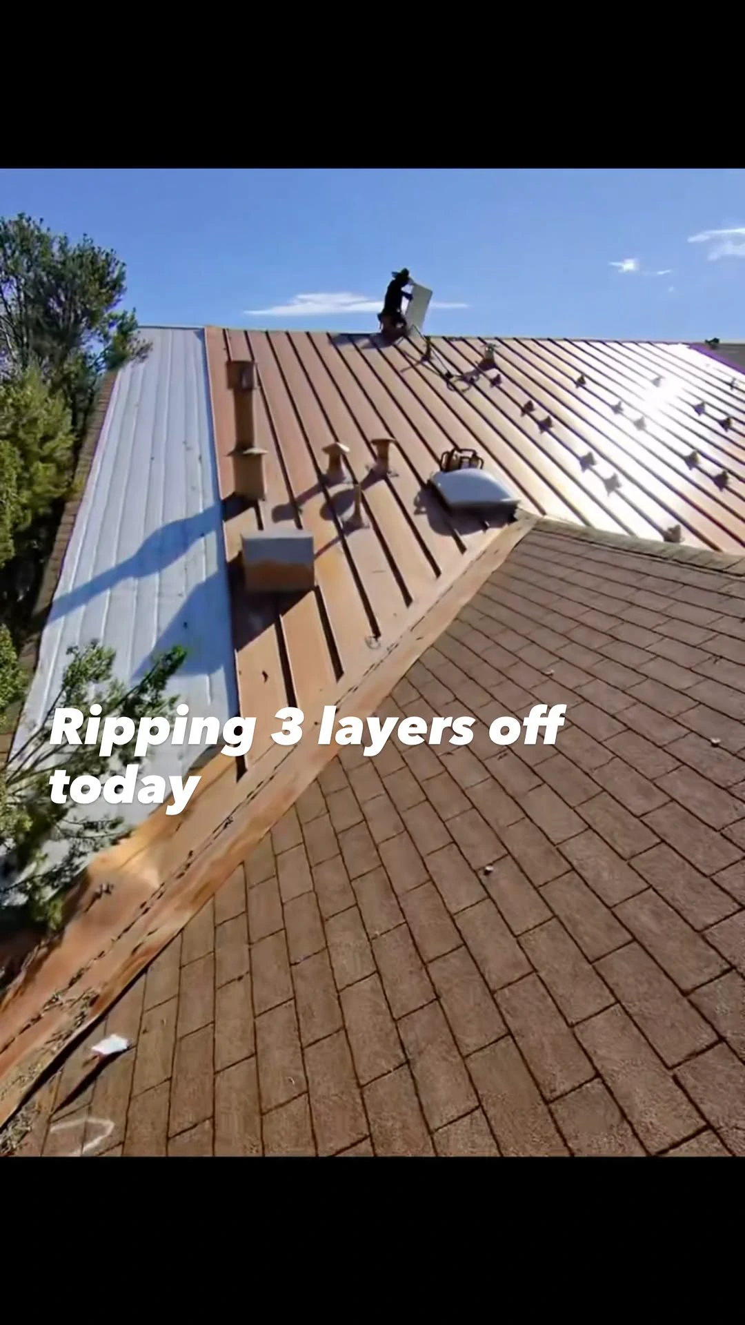 Roofing crew removing layers from a roof during a replacement project