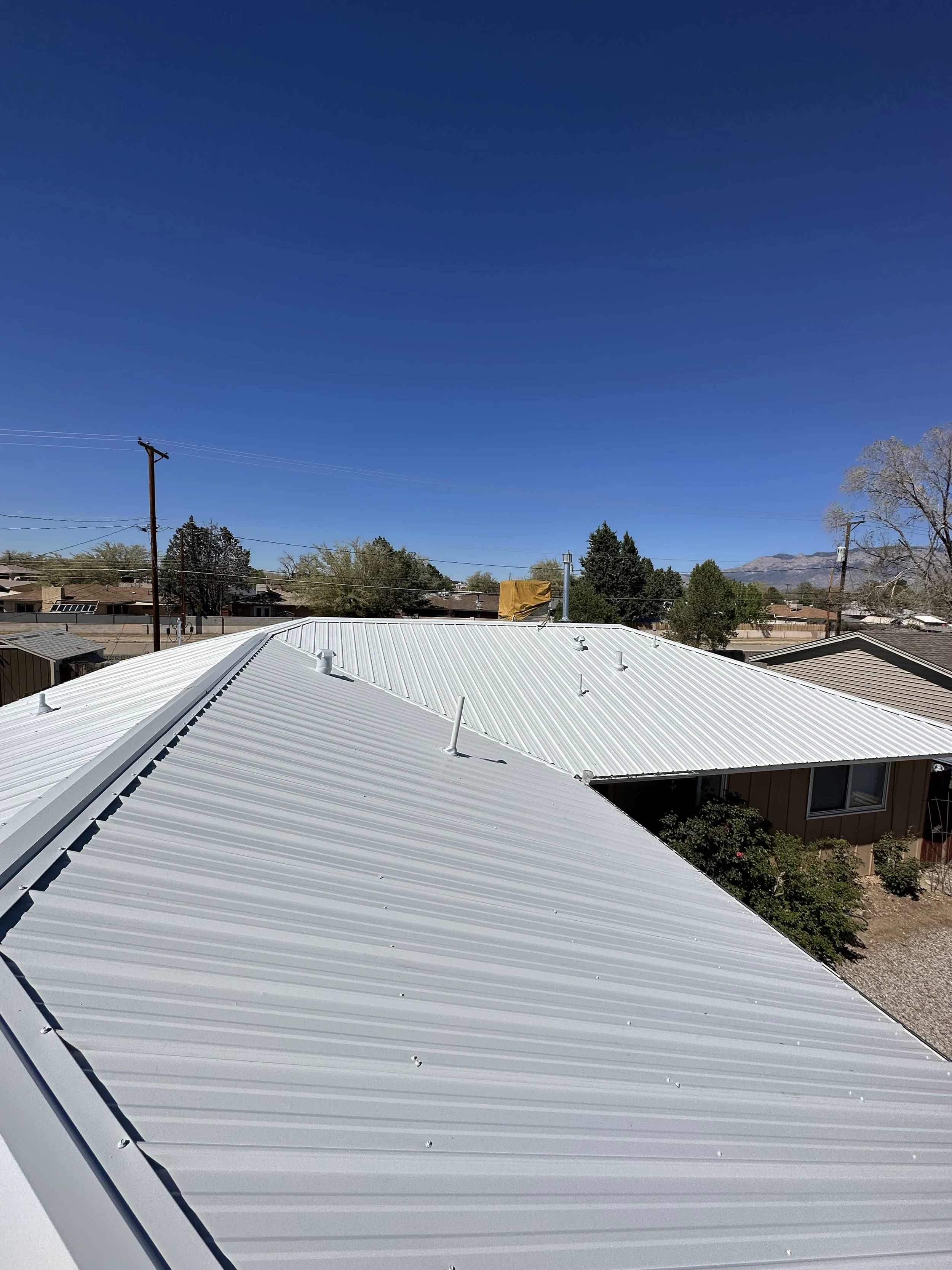 Newly installed white pro-panel metal roof on a residential home